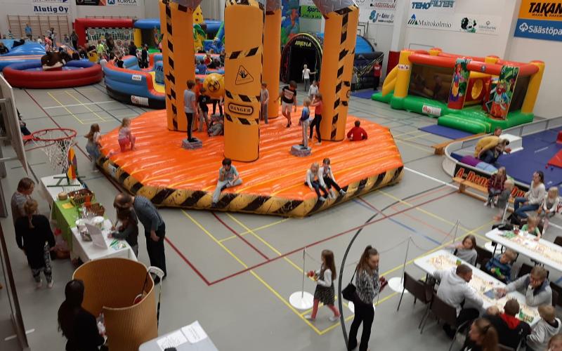 Hopsiksen liikkuva leikkipuisto liikuntasalissa: Megapallo Extreme keskellä, ympärillä Rock n Roll, IPS Arena, pomppulinnoja ja esterata